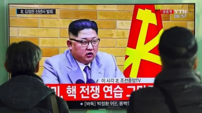 Pendukung Korea Utara menyaksikan pidato Kim Jong-un di televisi.