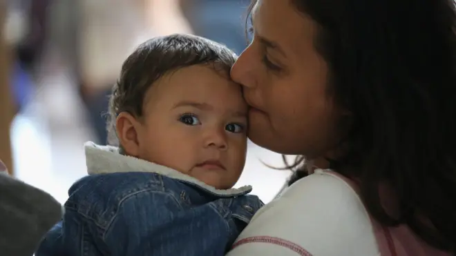 Mother kissing child