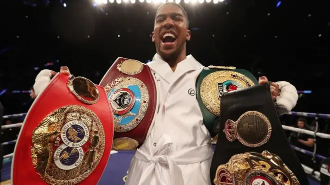 Anthony Joshua with four heavyweight title belts.