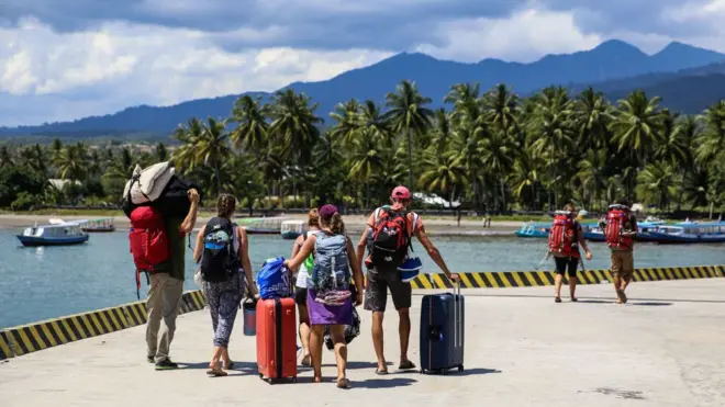 Sejumlah wisatawan meninggalkan lokasi hotel menuju pelabuhan di Gili Trawangan untuk menuju pulau Lombok, Selasa (07/08).