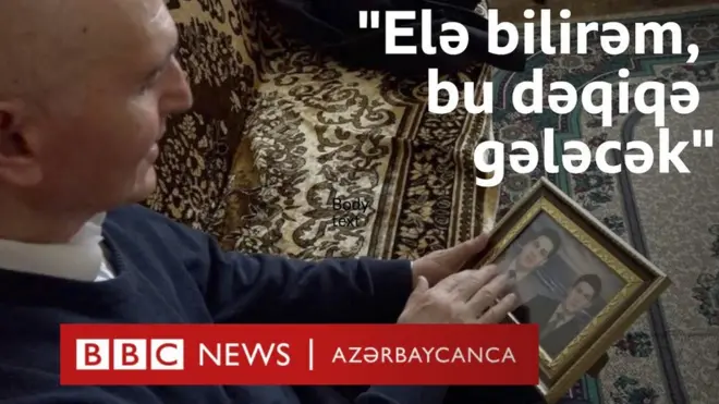 Əlində şəkilə baxan kişi