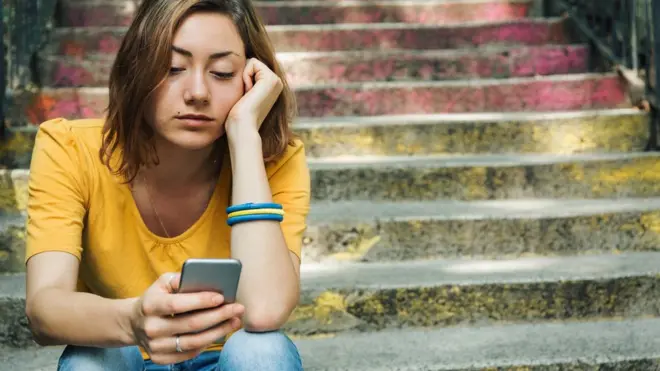 Девушка смотрит на телефон