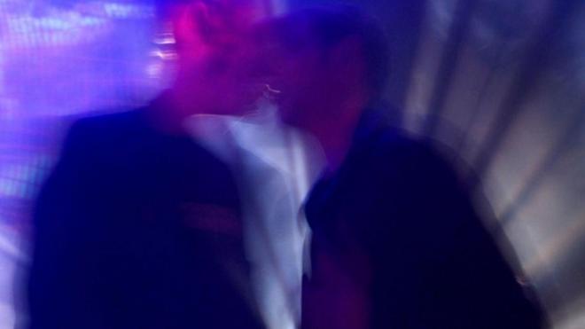 Dos hombres besándose en una imagen borrosa