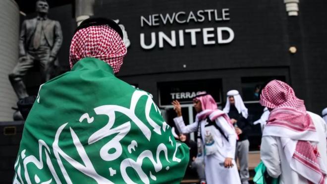 العلم السعودي على ظهر أحد السعوديين أمام نادي نيوكاسل يونايتد