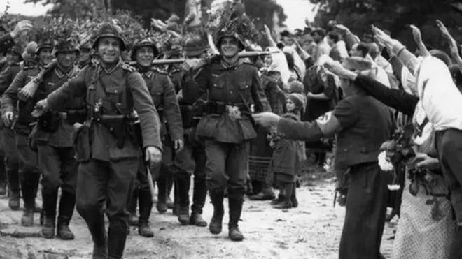 Wehrmacht soldiers entering Czechoslovakia in 1938 as locals salute