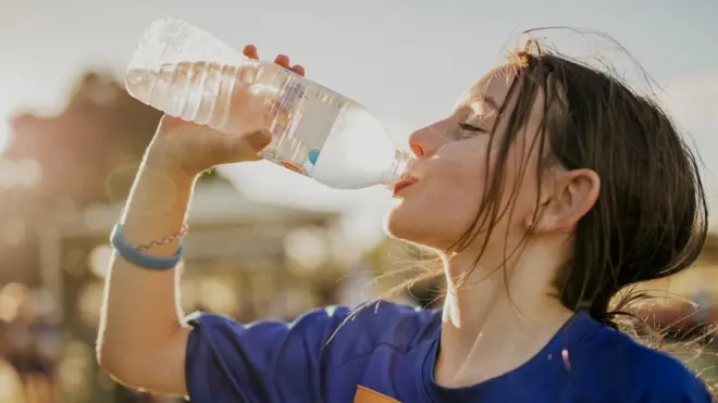 ప్లాస్టిక్ బాటిల్లో నీళ్లు తాగుతున్న యువతి