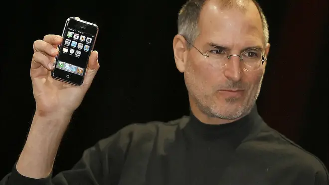 La leyenda que acompaño a esta foto fue: "El jefe ejecutivo de Apple Steve Jobs presentó un nuevo teléfono móvil que puede usarse para escuchar música y tomar fotos, un aparato muy esperado llamado 'iPhone', en la Conferencia Macworld el 9 de enero 2007 en San Francisco".