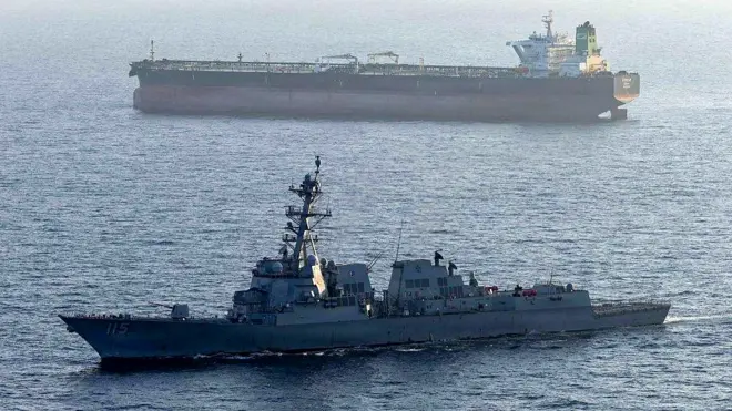 A US military ship is seen in the foreground in the Arabian Sea in April, while another ship is seen in the background.
