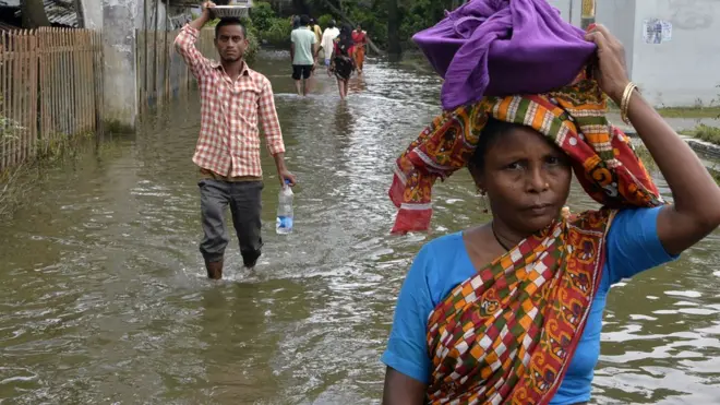 Indian villagers dey try pack the few things wen dem fit carry as flood water don cover their house for Kishanganj village inside Bihar state