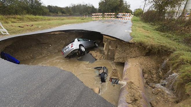 An image released by San Antonio Fire Department show to vehicles in a sinkhole, one almost completely submerged