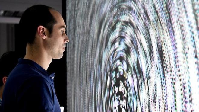 Мужчина рассматривает экран с пузырьками, которые помогают найти баланс при повреждении внутреннего уха. Университет Гренобля, Франция, ноябрь 2017 года.