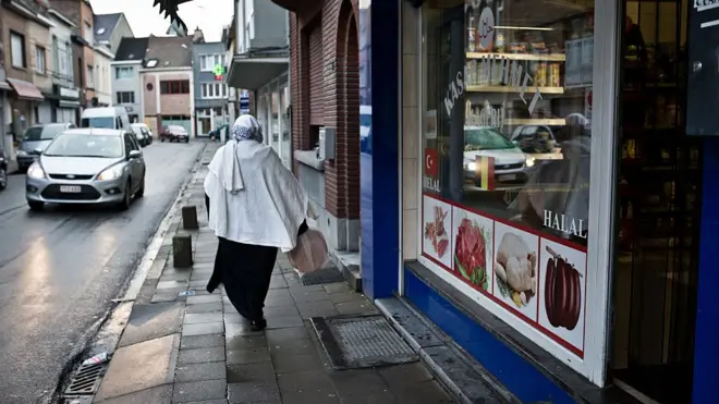A Muslim woman walks past halal shops on January 13, 2014 in Vilvoorde, Belgium
