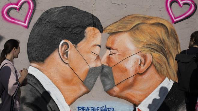 前柏林牆的街頭藝術畫，畫面顯示美國總統特朗普和中國國家主席習近平戴著防護口罩在接吻。
