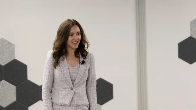 İlayda şık bir takım elbiseyle sunum yaparken