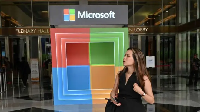 Microsoft logosu önünde bulunan bir kadın