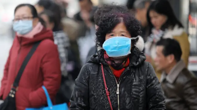 Chinese residents wear masks while waiting at a bus station near the closed Huanan Seafood Wholesale Market in Wuhan