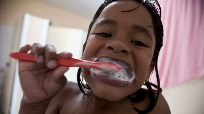 Criança escovando os dentes