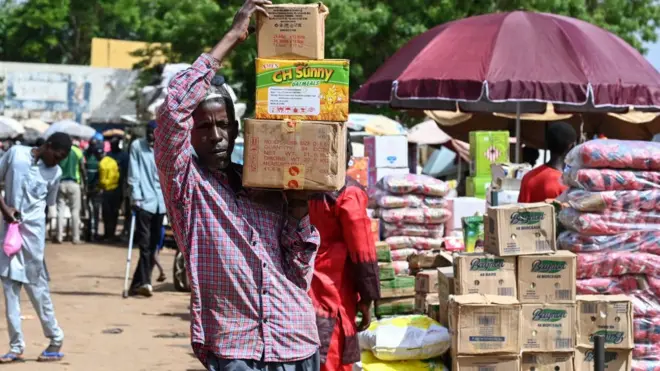 Un homme transporte des caisses de nourriture au marché principal de Niamey, le 8 août 2023