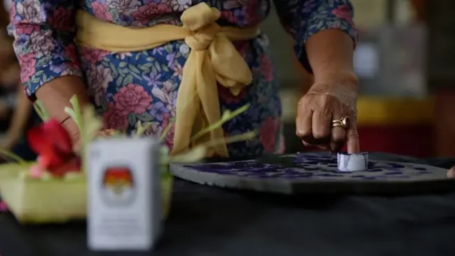 Seorang warga Kota Denpasar tengah mencelupkan tangannya dalam botol tinta dalam Pilpres 9 Juli 2014.