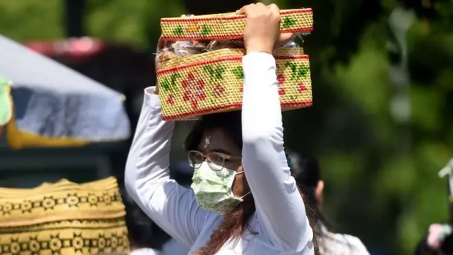 Seorang perempuan Bali memakai masker saat perayaan Galungan di Pura Jagatnata, Denpasar, pada 19 Februari lalu.