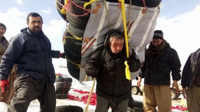 رجل في السبعين من عمره يحمل 120 كيلو غرام من إطارات السيارات على ظهره عشرات الكيلومترات