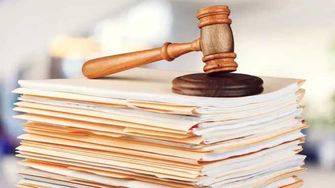 Пачка судебных документов и молоток судьи
