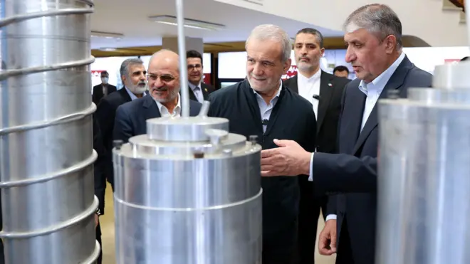 مسعود پزشکیان رئیس جمهور ایران در کنار محمد اسلامی، رئیس سازمان انرژی اتمی ایران (نفر اول از سمت راست) در بازدید از نمایشگاه «دستاوردهای هسته‌ای» در فروردین امسال