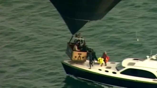 People in hot air balloon basket given life jackets from boat