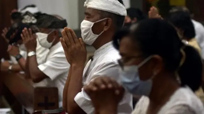 Umat Katolik menerapkan protokol kesehatan dalam ibadah misa malam Natal di Gereja Katolik Paroki Roh Kudus Babakan, Badung, Bali, Kamis (24/12/2020).
