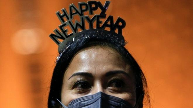 A woman, wearing a protective face mask and a headband, looks on at the Bundaran Hotel Indonesia roundabout where people usually celebrate on New Year's Eve in Jakarta, Indonesia, December 31, 2021. REUTERS/Willy Kurniawan