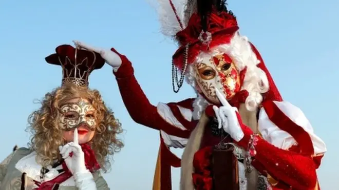 Two masked revellers pose in Venice's Riva degli Schiavoni