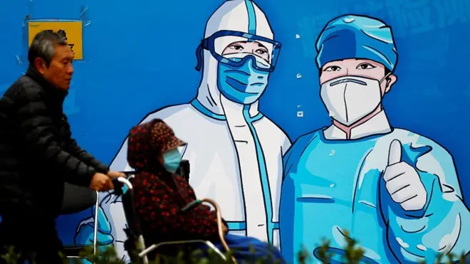 新冠宣傳畫和坐輪椅的醫院病人