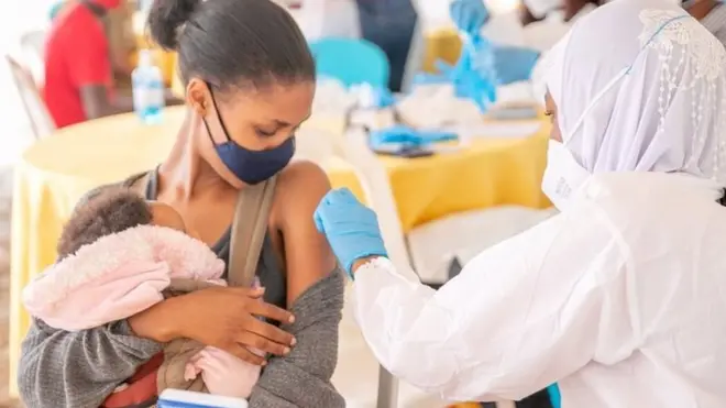 Umugore uteruye umwana uri guterwa urukingo rwa Covid mu mujyi wa Kigali