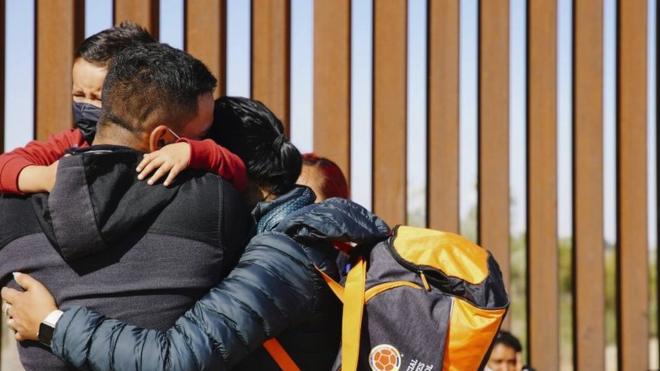 Una familia se abraza en la frontera entre Estados Unidos y México