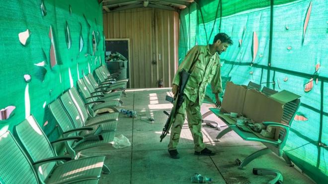 An Afghan army soldier surveys belongings left by the US military inside the Bagram Air Base, some 50 kilometers north of the capital Kabul.