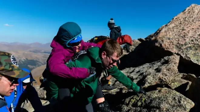 Группа в 27 человек помогала туристке взбираться на вершину.