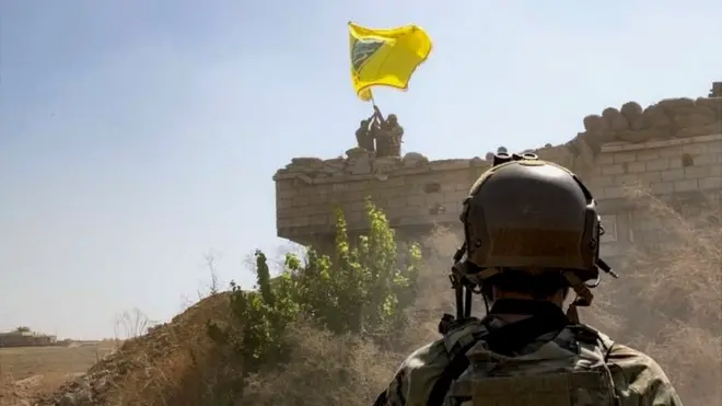 Военный и флаг "Демократических сил Сирии"