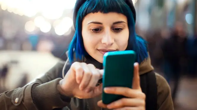 فتاة تتصفح هاتفا ذكيا