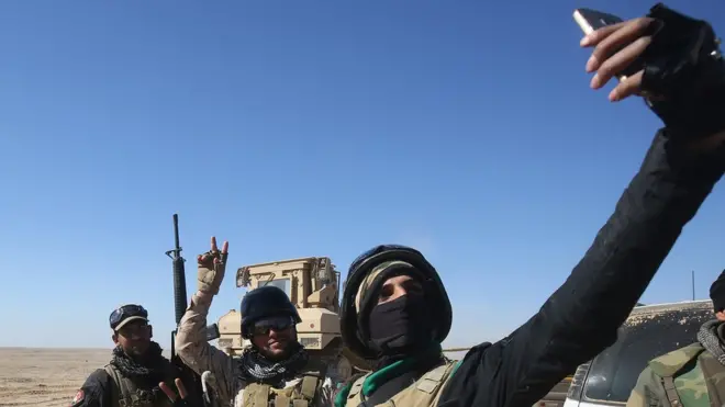 جنود عراقيون يلتقطون صورة "سيلفي" على الطريق إلى قرية الشيخ يونس، جنوب الموصل.