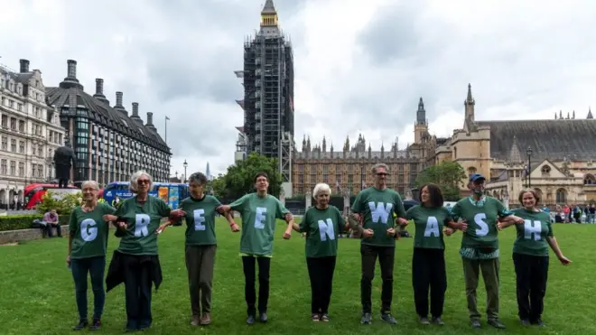 Protesters in London former the word greenwash during a march in 2021