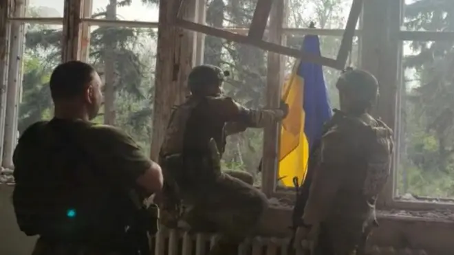 Soldiers raising Ukraine flag