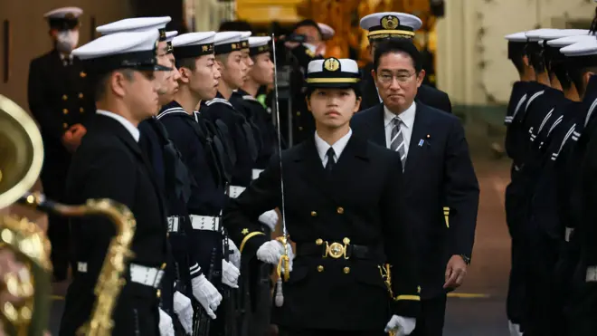 Japan's Prime Minister Fumio Kishida (centre R-facing) receives an honorary salute aboard the Japanese helicopter carrier JS Izumo during an "International Fleet Review", held by Japan's Maritime Self-Defense Force with some 12 other countries, in Sagami Bay, off Kanagawa Prefecture, on November 6, 2022