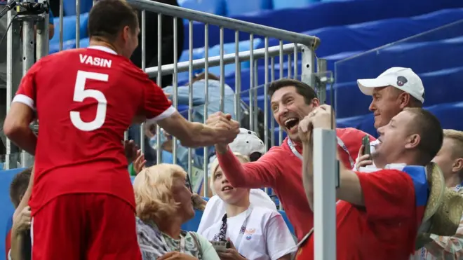 Игрок сборной России Виктор Васин (слева) общается с болельщиками после победы в матче
