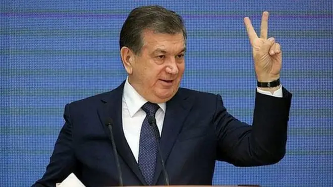 Президент Мирзиёев бармоқлари билан ғалаба аломатини кўрсатмоқда.