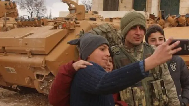 صبية سوريون يلتقطون صورا مع جندي تركي