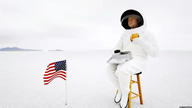 A stock image of an astronaut eating a hamburger