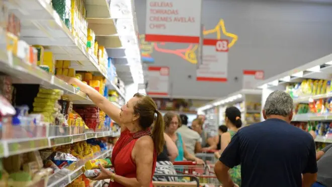 Mulher pega alimentos processados e ultraprocessadosboné esportes da sorte gremioprateleira