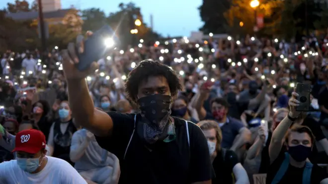 Demonstrators sing "Lean On Me" near the White House during a peaceful protest against police brutality and the death of George Floyd, on June 3, 2020 in Washington, DC