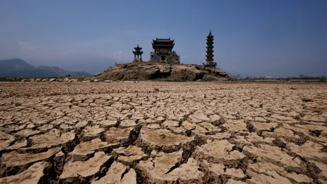 Вид на пагоды, которые находятся на остове в озере Поянху в китайской провинии Цзянси. Обычно пагоды наполовину стоят в воду, но озеро высохло из-за жары