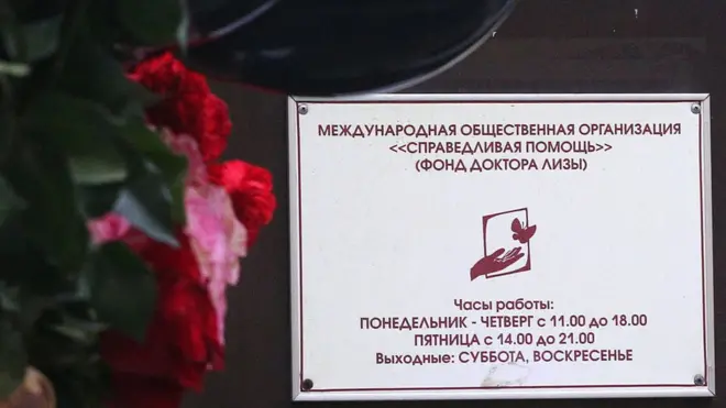 Люди несут цветы к фонду Елизаветы Глинки "Справедливая помощь"